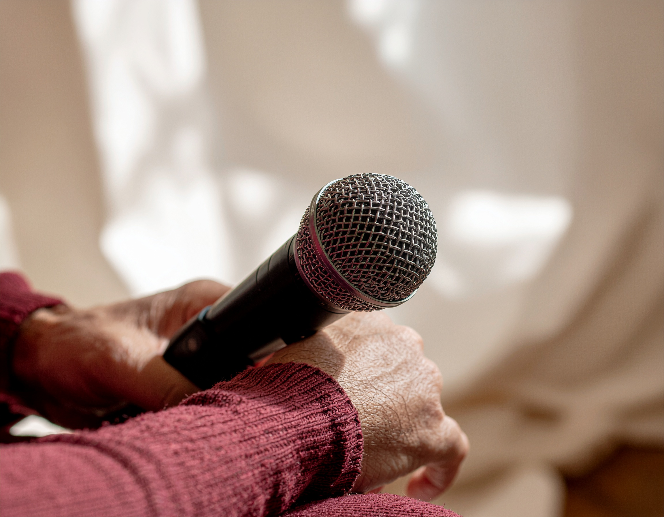 Close-up of a hand adjusting the boom arm on a podcast microphone.